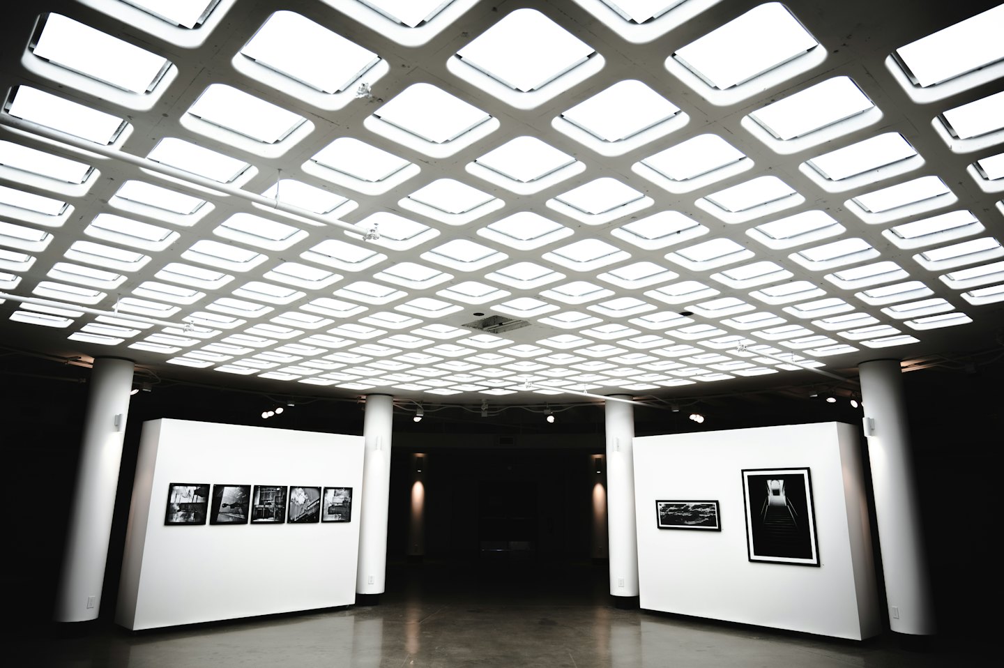 Galleria d'arte moderna con quadri incorniciati su pareti bianche.