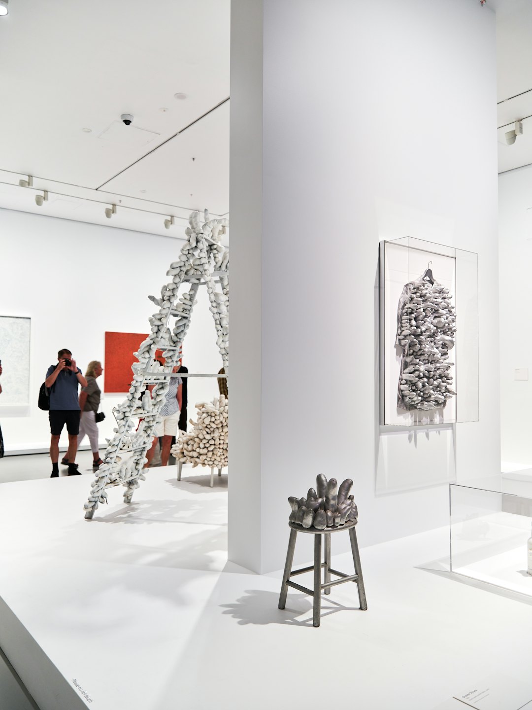 Visitatori osservano arte contemporanea in una galleria moderna.