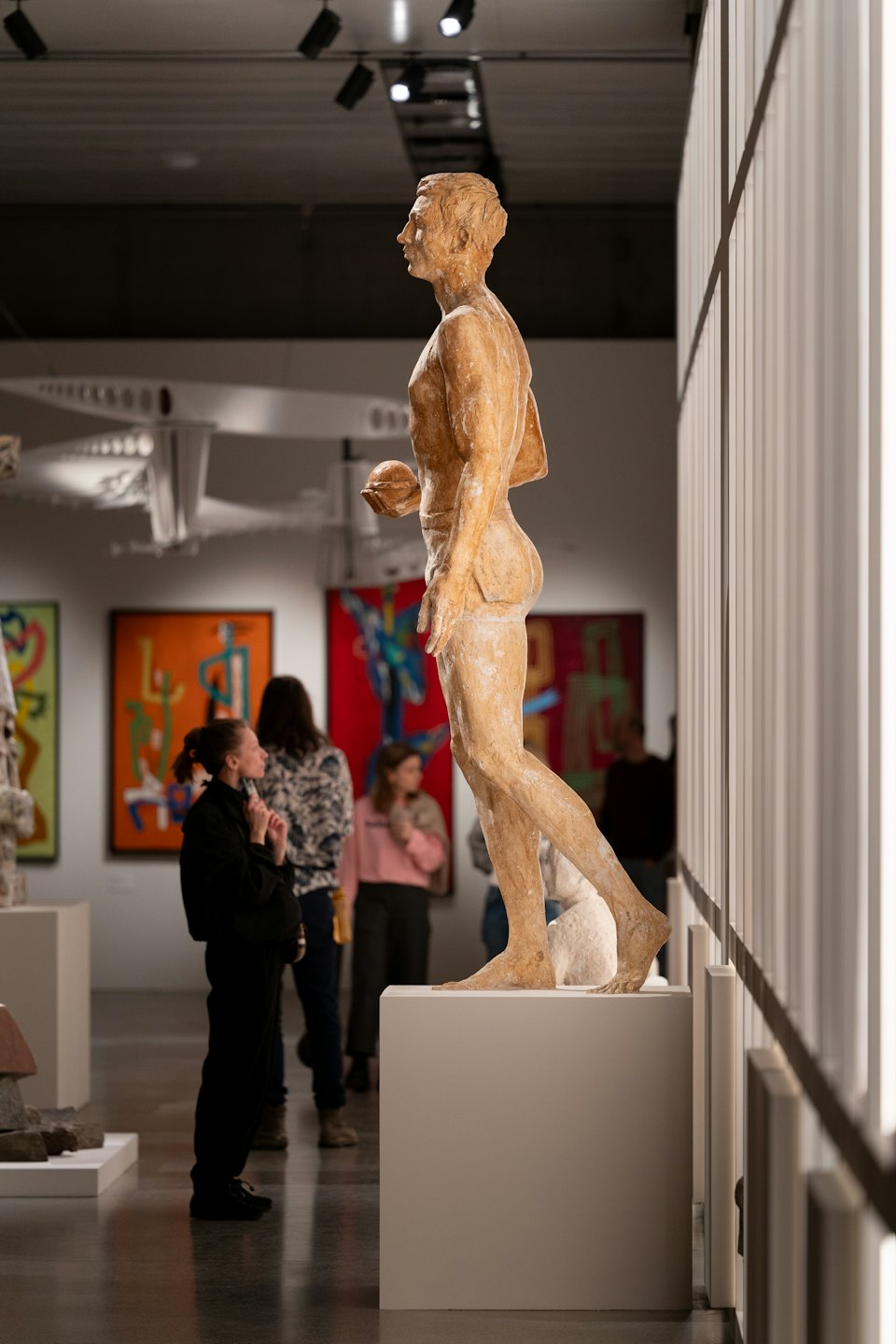 Donna osserva una scultura chiara in una galleria d'arte moderna.
