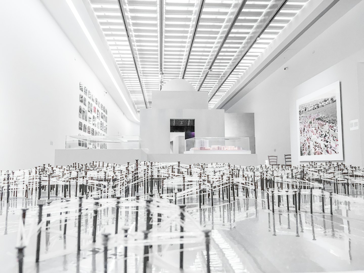 Galleria d'arte moderna con installazione di corde e opere d'arte alle pareti.